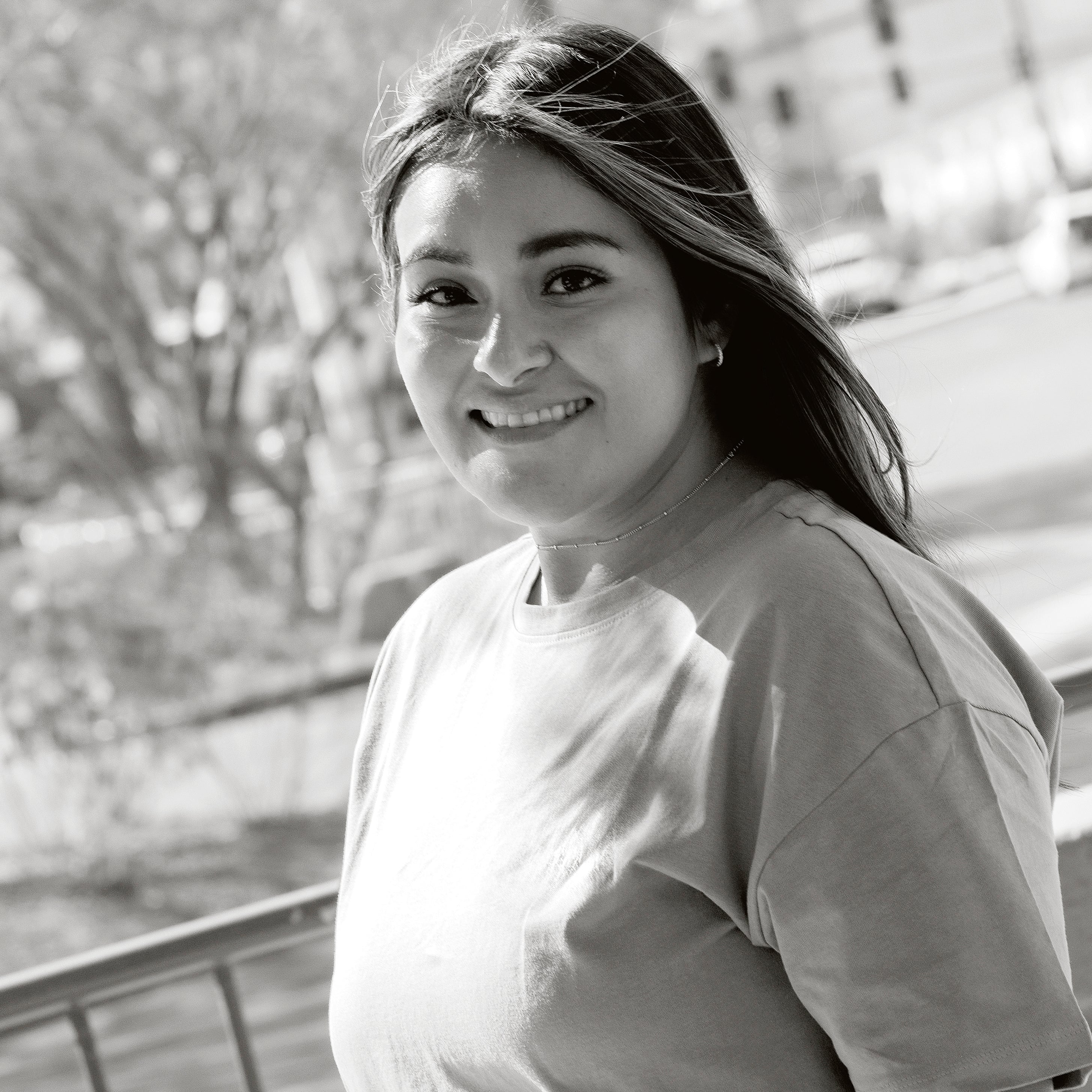 Frau mit langen Haaren im Freien bei sonnigem Wetter.