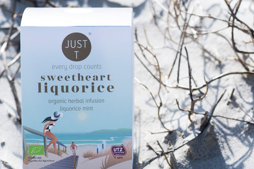 Weiße Teeverpackung auf sandigem Hintergrund mit der Aufschrift "Just T sweetheart liquorice".